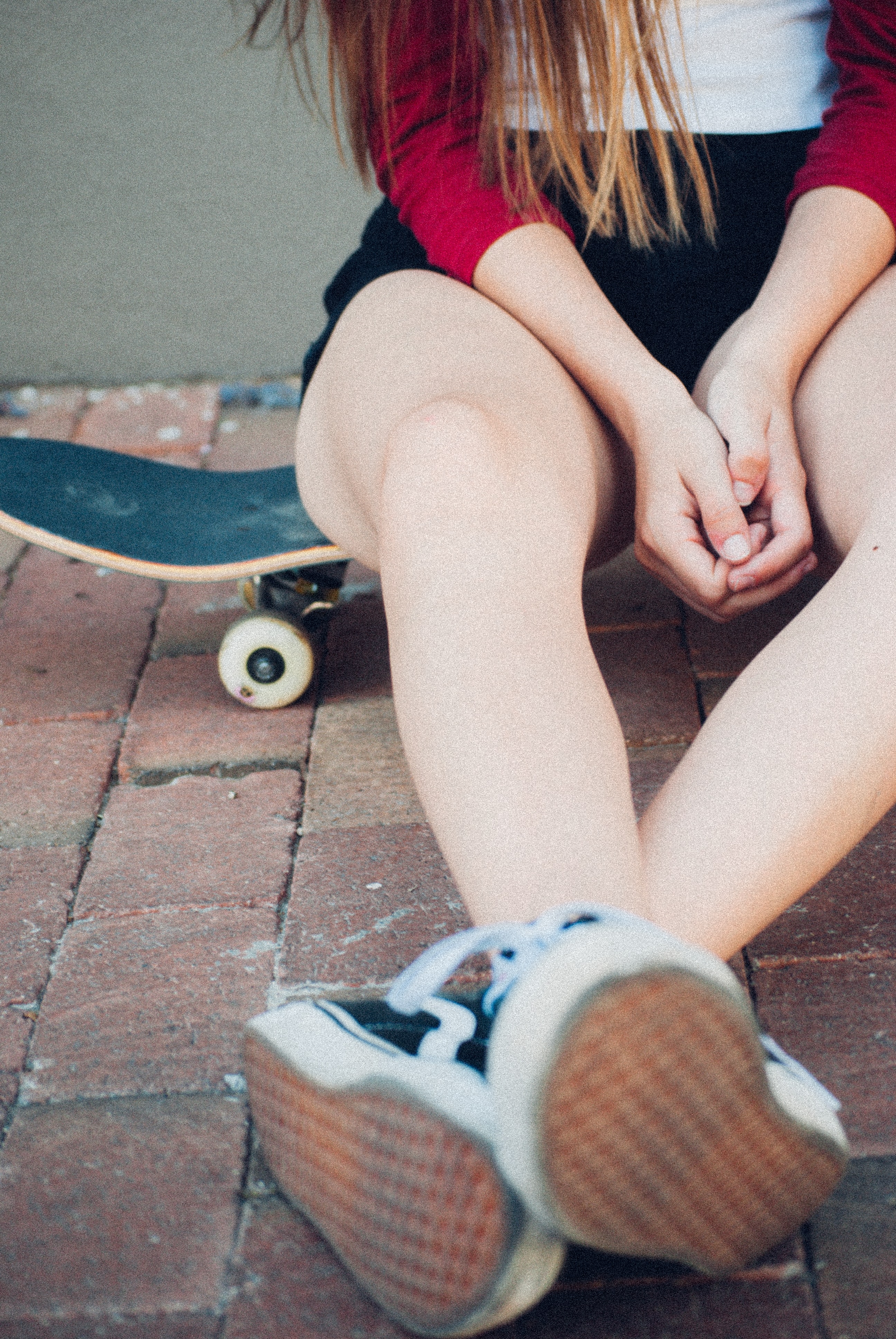 Girl sitting on a skateboard wearing Vans shoes in black and white - 3 Ways I Started Embracing My Most Authentic Self [Millennial Perspective]