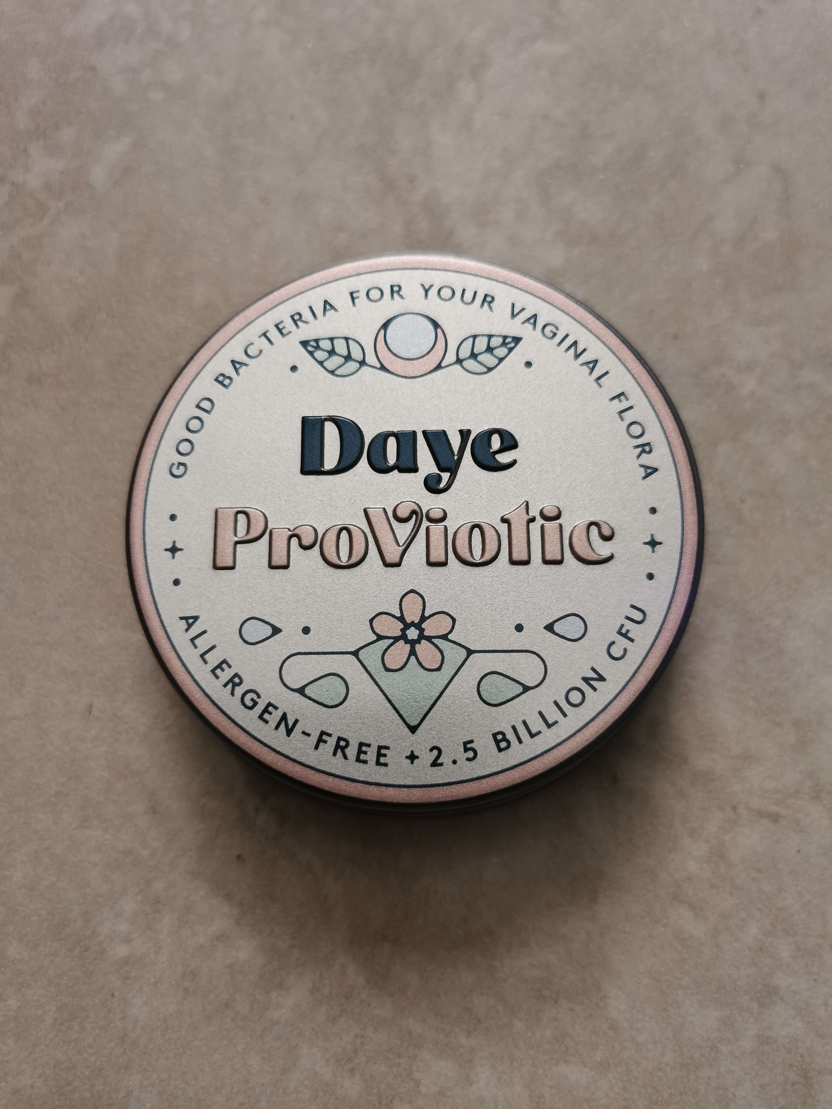 Allergen-free probiotic supplement tin for vaginal health, featuring floral design and 2.5 billion CFU content.