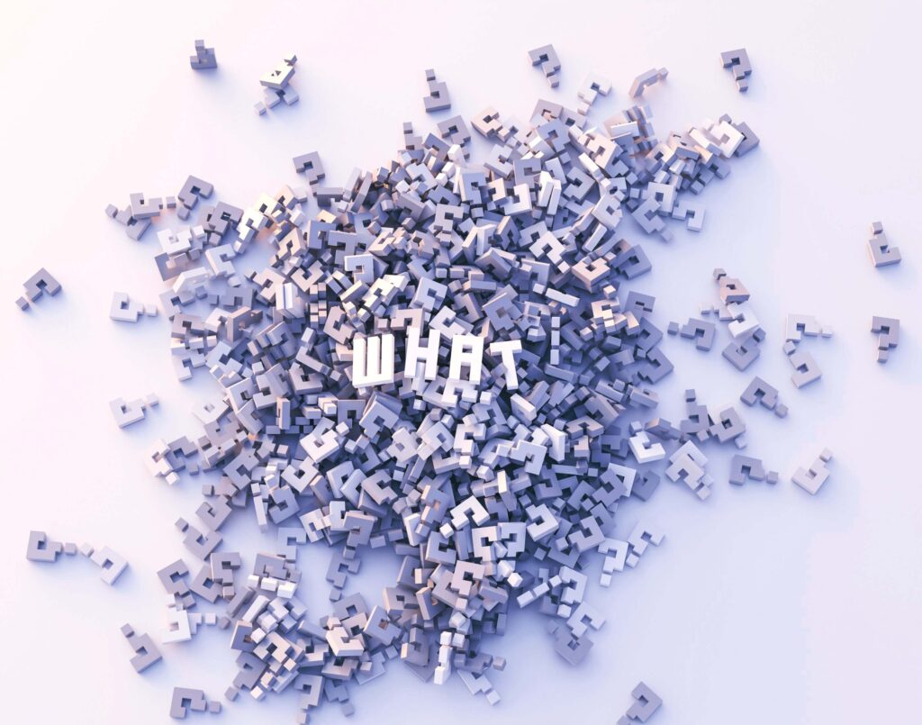 Pile of 3D grey question marks surrounding the word WHAT on a white surface, symbolising confusion and inquiry.