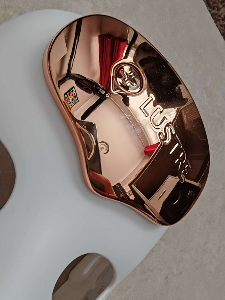 Rose gold and white Lustre beauty device with sleek design on a marble surface.