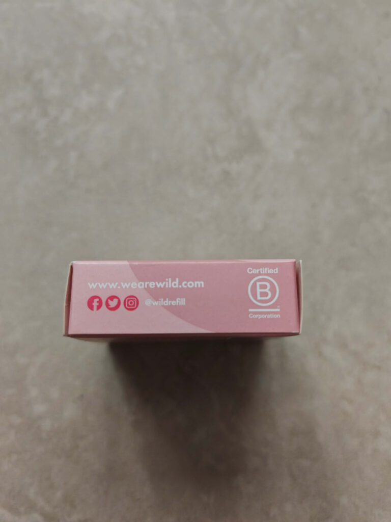 Pink Wild Deodorant box with social media icons and Certified B Corporation logo on a grey background.