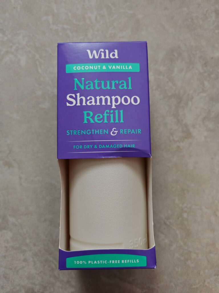 Coconut vanilla shampoo refill by Wild for dry hair, eco-friendly, plastic-free packaging on a grey surface.