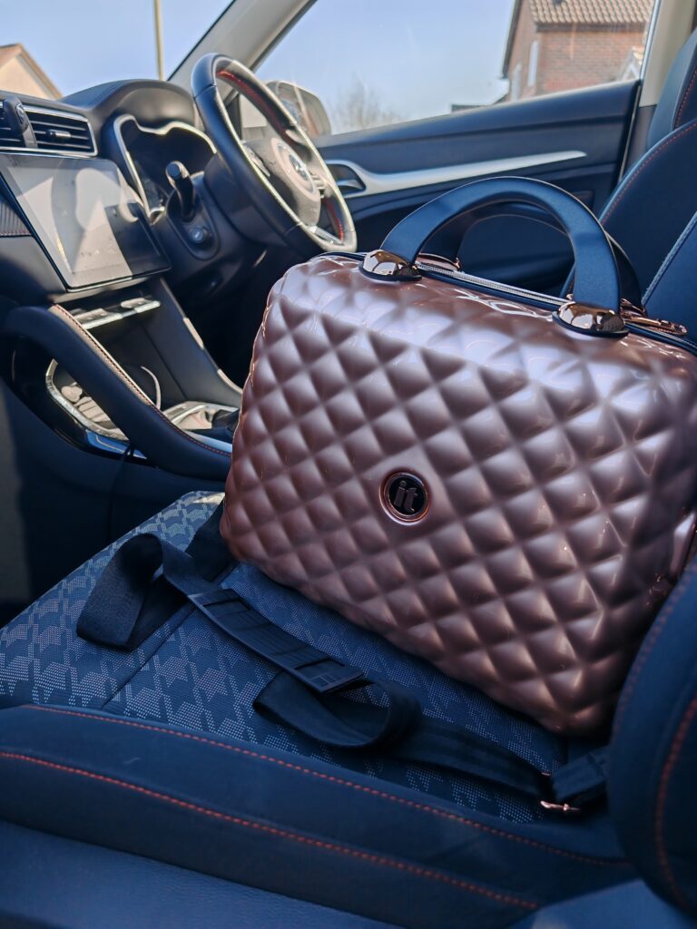 Stylish quilted luggage on car seat, showcasing luxury travel essentials in a modern interior setting.