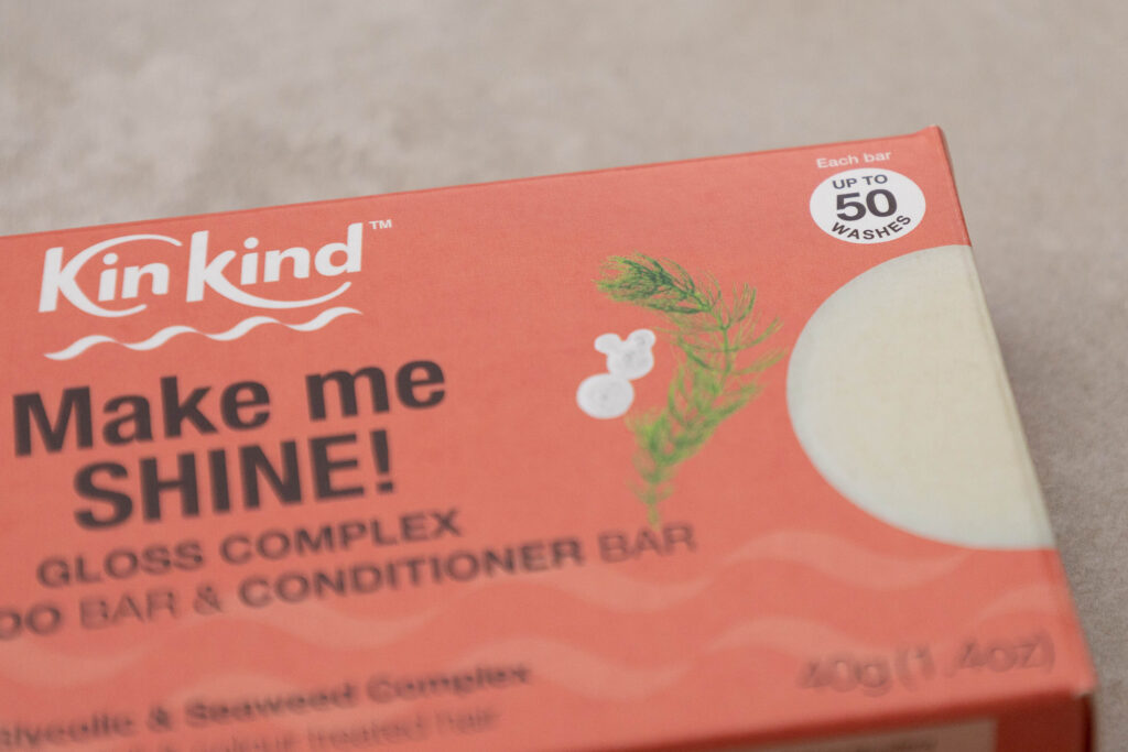 KinKind gloss complex shampoo bar packaging, promises shiny hair, up to 50 washes, with a vivid orange design.