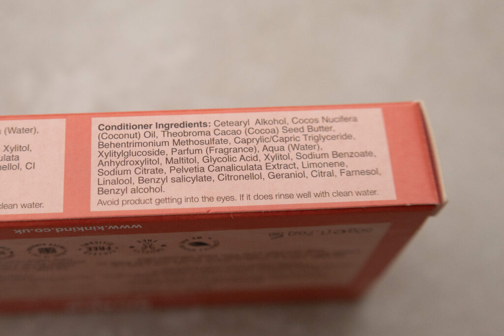Conditioner ingredients list with coconut oil, cocoa butter, fragrances, and care instructions on a product box.