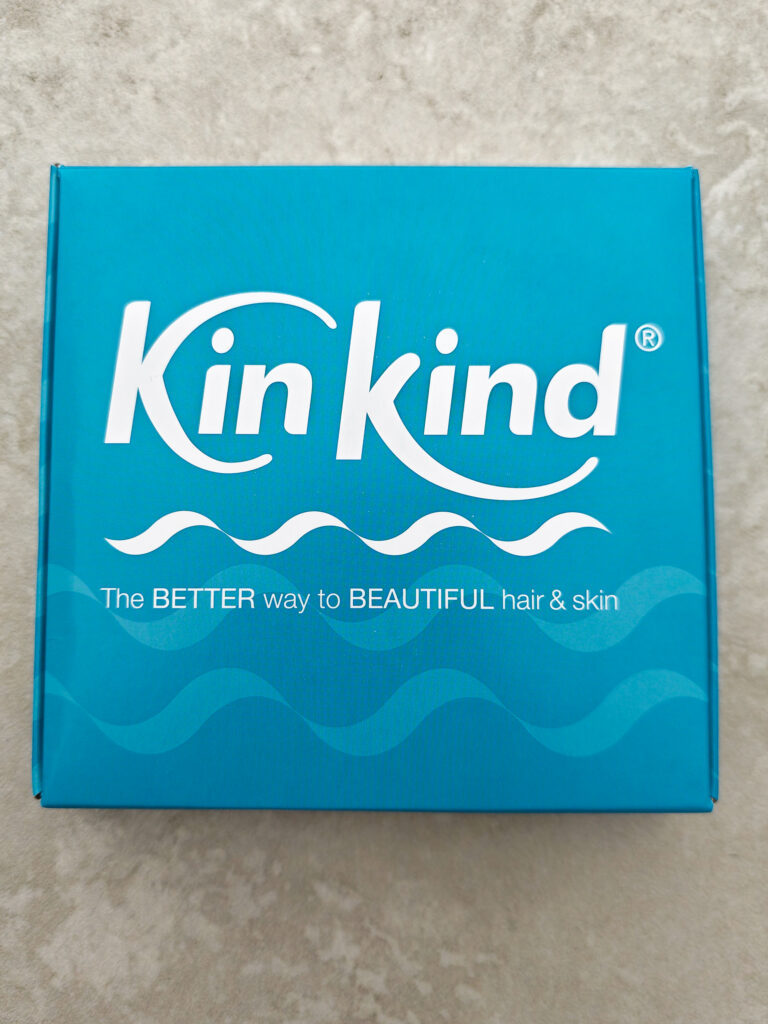 Turquoise KinKind box with The BETTER way to BEAUTIFUL hair & skin slogan, promoting eco-friendly products.