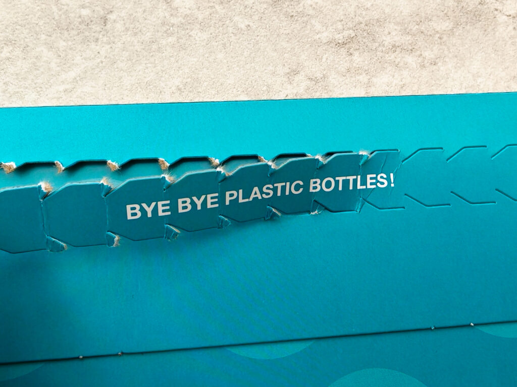 Cardboard packaging with Bye Bye Plastic Bottles! message, promoting eco-friendly and sustainable practices.