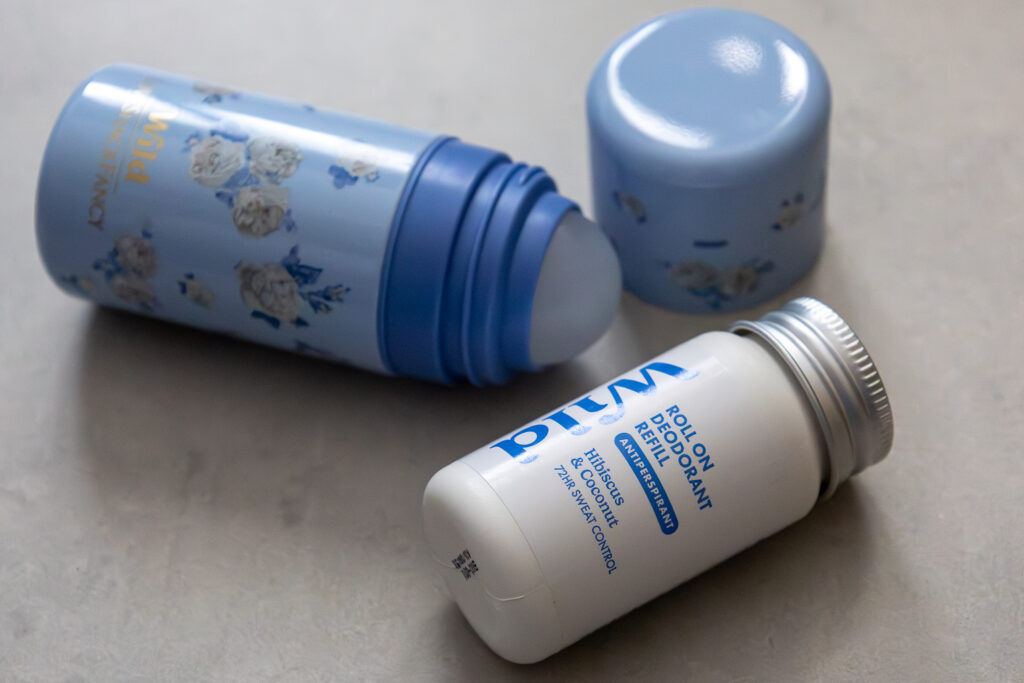 Blue floral deodorant container with a white roll-on deodorant refill bottle, hibiscus and coconut scent.