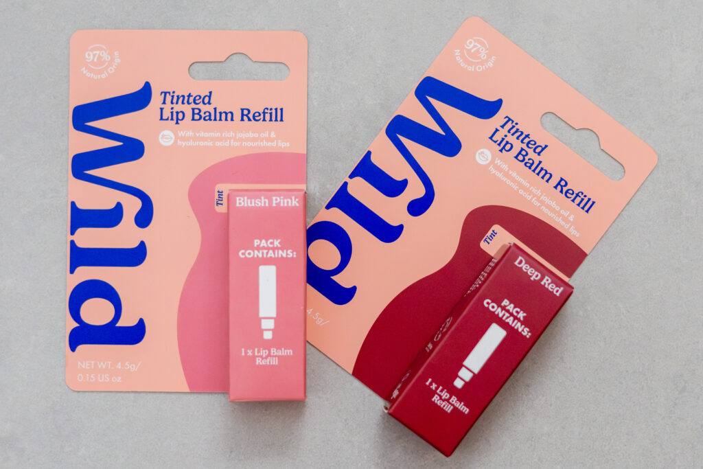 Wild tinted lip balm refills in Blush Pink and Deep Red on grey background. Contains vitamin-rich jojoba oil.